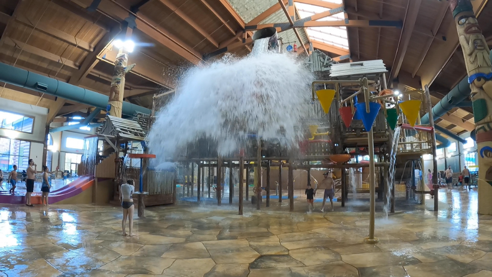 Huge bucket dropping water on people below. The bucket if on top of Fort MacKenzie in Great Wolf Lodge, Traverse City