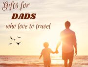 A blog post featuring gift ideas for dads who love to travel. Photo of a father and son walking on a beach at sunset.