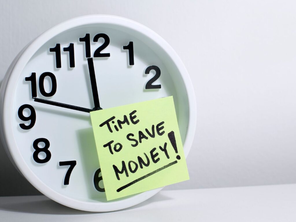 A clock with a post-it notes on it. The note says "time to save money". To inspire money savings to make that dream trip a reality.