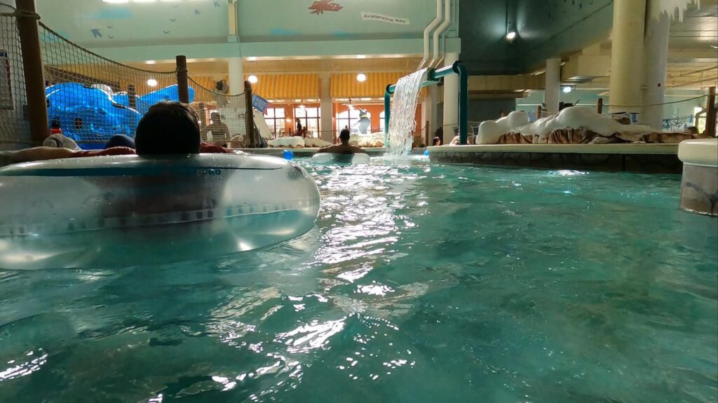 Guests floating on tubes along the relaxing Lazy River at Avalanche Bay Indoor Waterpark — a gentle, winding waterway perfect for all ages to unwind and enjoy.