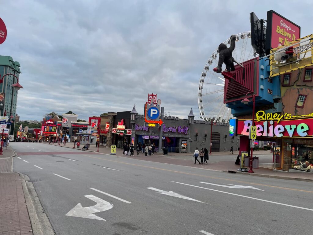 Colorful view of Clifton Hill in Niagara Falls with bright lights, attractions, and bustling crowds.