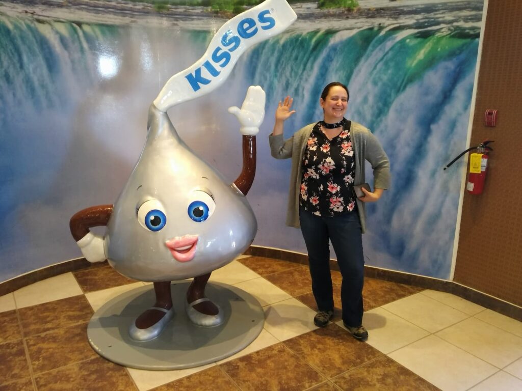 Person posing with a giant Hershey’s Kiss statue inside the Hershey’s Chocolate World store in Niagara Falls.