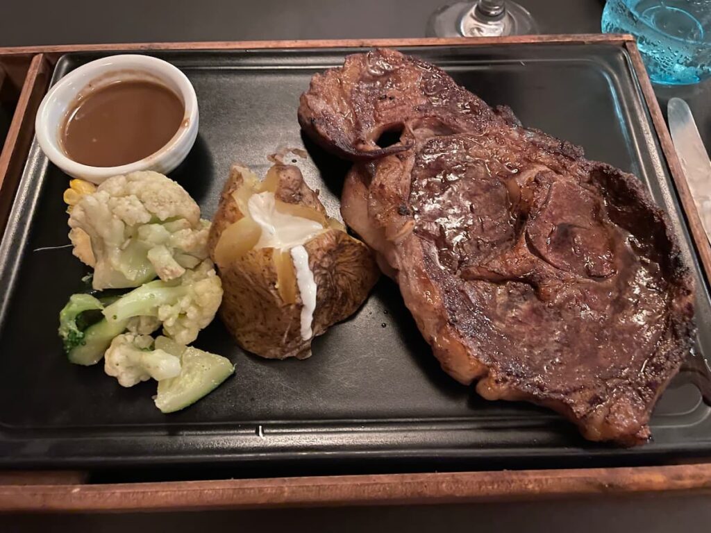 Juicy grilled steak with a side of roasted potatoes and sautéed vegetables at Seaside Grill in Dreams Flora.