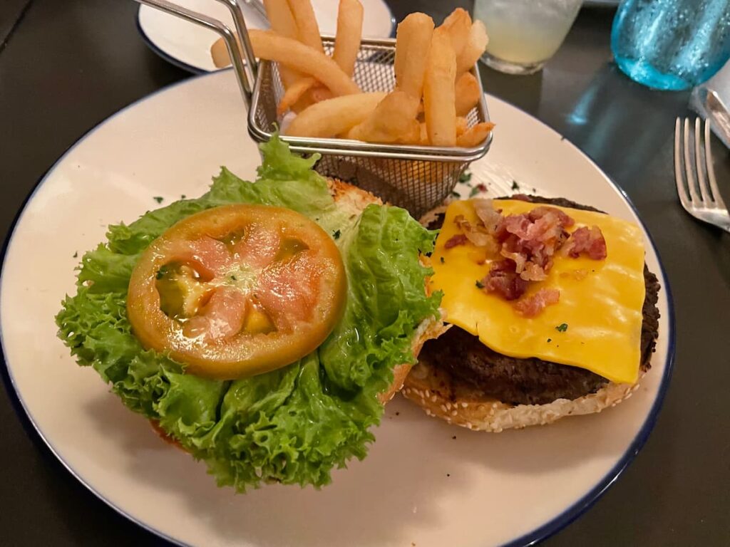 Classic hamburger with lettuce and tomato served with golden fries at Seaside Grill in Dreams Flora.