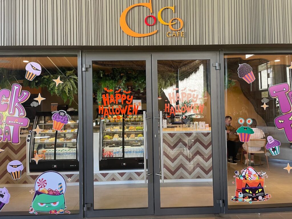 Cozy Coco Café at Dreams Flora with a pastry display, coffee bar, and comfortable seating, perfect for snacks and specialty drinks.