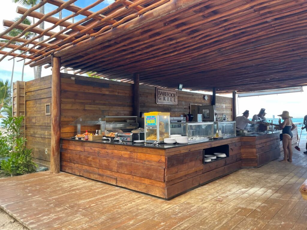 Casual outdoor Barefoot Grill at Dreams Flora, located by the pool and beach, serving quick bites in a relaxed, tropical setting.