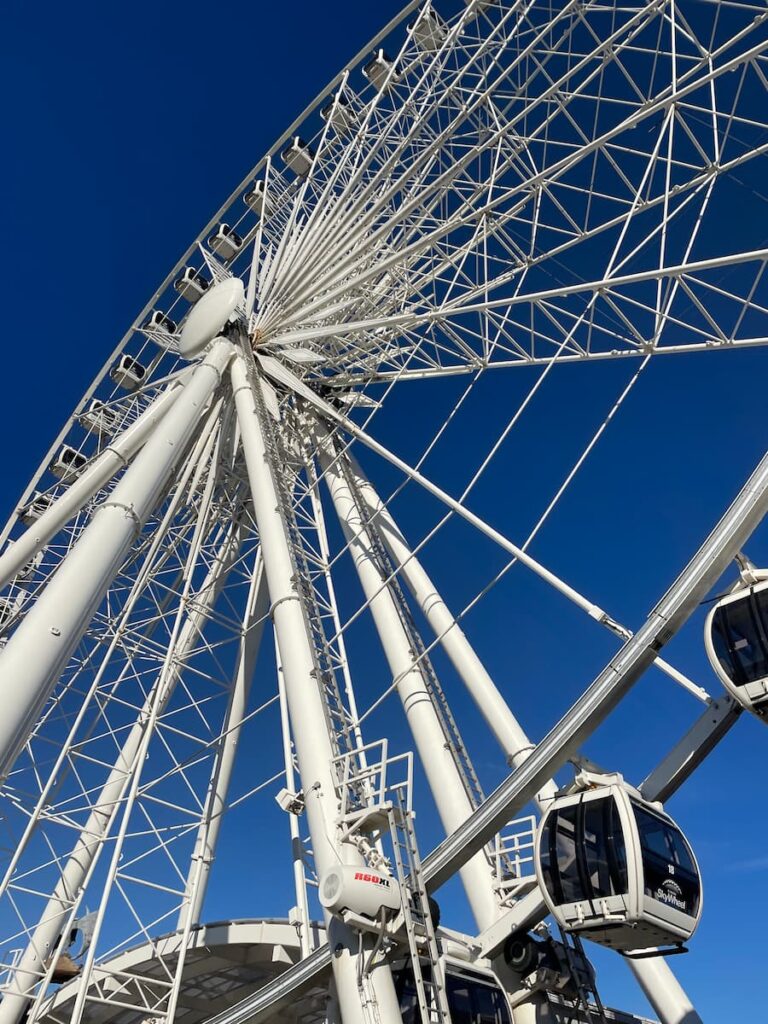Niagara SkyWheel towering over Clifton Hill with enclosed gondolas and scenic views of Niagara Falls in the background.